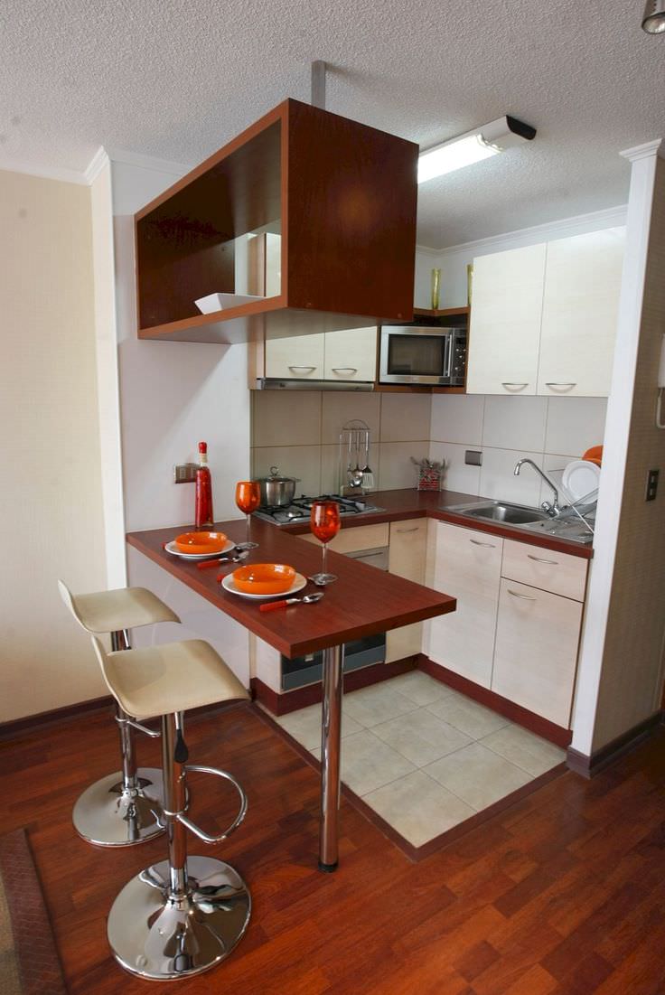 دکوراسیون آشپزخانه کوچک و نقلی که پیشخوان آن با صندلی های مخصوص اپن، تبدیل به میز ناهار خوری شده است